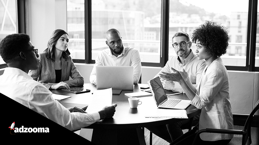 Black woman addressing colleagues at a corporate business meeting